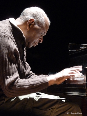 A photo of the right profile of Muhal Richard Abrams playing the piano copyright 2014 Richarda Abrams